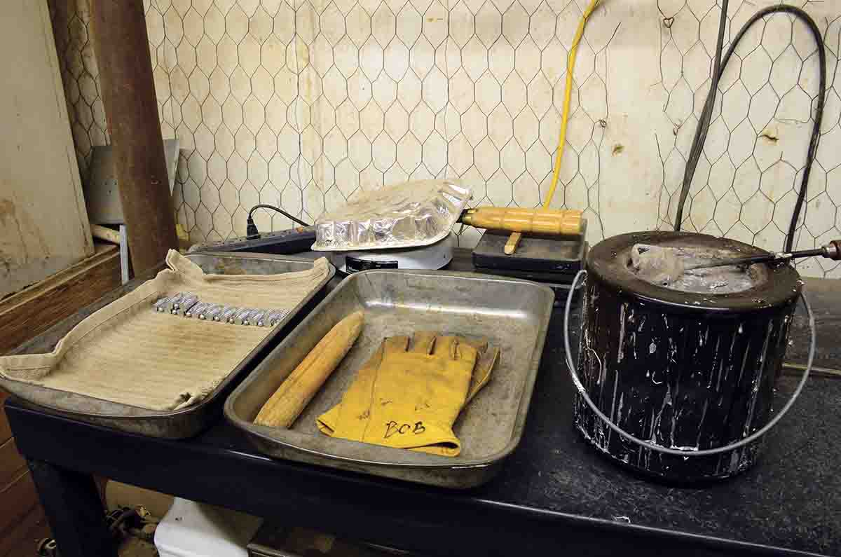 A bullet mould under a foil pan is shown preheating on an electric hot plate.